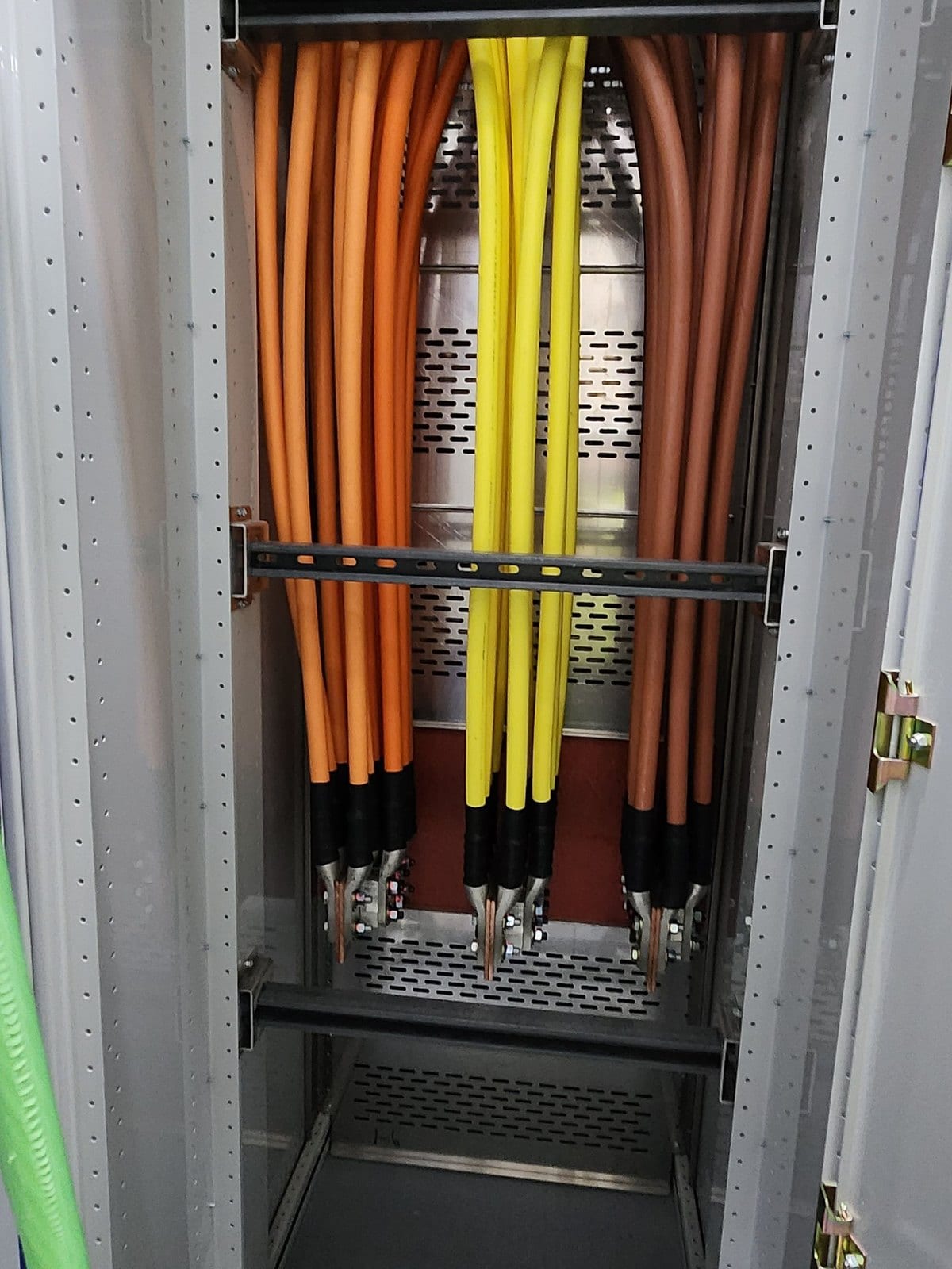 Parallel feeder cables terminated onto switchgear bus bars behind a bracing rail